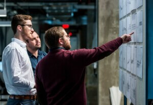 people looking at work hung on a wall
